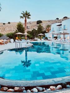 a large pool with blue water in a resort at Caesars Gardens Hotel & Spa - Adults Only in L&iacute;ndos