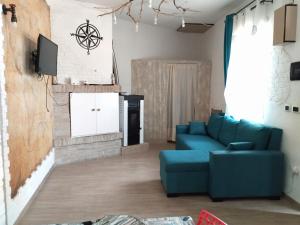 a living room with a blue couch and a tv at Rosa dei Venti house in Campomarino