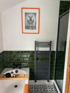 a green tiled bathroom with a tub and a sink at Fettlers Cottage, Cumbria in Kirkby Stephen +19 photos