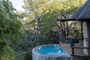 a hot tub on a deck with trees at Horizon by Ongava in Okaukuejo