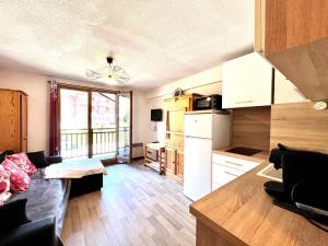 a living room with a couch and a kitchen at Studio à Praz-sur-Arly in Praz-sur-Arly