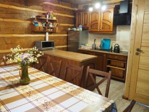 a kitchen with a table with a vase of flowers on it at Grubałówka in Rogówko