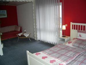 a bedroom with a bed and a red wall at Ferienwohnung Veronika Pape in Schmallenberg