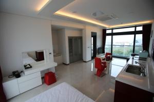 a hotel room with a bed and a sink and a bathroom at Jeju Jayle Blanc in Jeju