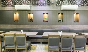 a dining room with wooden tables and chairs at Treebo Bliss in Jaipur