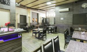 a dining room with tables and chairs in a restaurant at Treebo Bliss in Jaipur