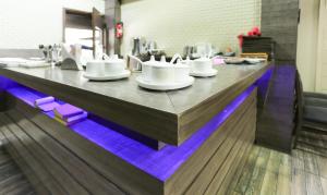 a table with white cups and saucers on it at Treebo Bliss in Jaipur