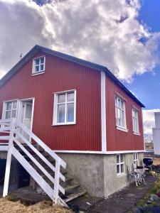 海德利桑德Seaside Retreat, Glacier View的一栋红色的房子，有一条白色的楼梯通往它
