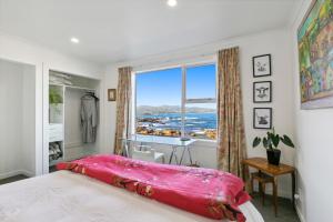 1 dormitorio con ventana grande y cama en Pacific Ocean seafront home near airport, en Wellington 15 fotos más