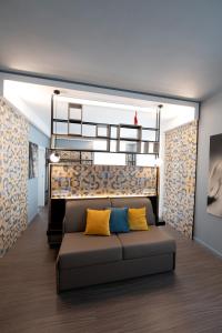 a living room with a couch with yellow and blue pillows at Bed In Centro in Naples