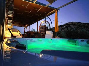 a green bath tub sitting under a pergola at Elaia Rest House Retreat in nature in Fréngaina