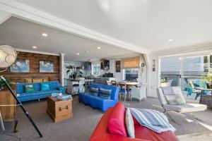 sala de estar con sofás azules y cocina en Pacific Ocean seafront home near airport, en Wellington
