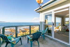Un balcón con sillas y vista al mar. en Pacific Ocean seafront home near airport, en Wellington