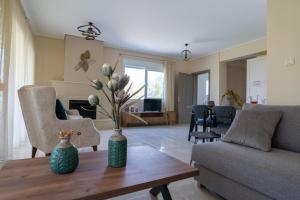 a living room with a vase on a wooden table at Villa Brezza Di Mare - Agios Stefanos Volos in Kritharia