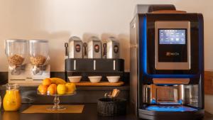 a coffee machine sitting on a counter with a bowl of oranges at Hotel La Renardière Morzine in Morzine