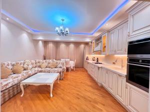 a living room with a couch and a table at Park Azure 0313 in Baku