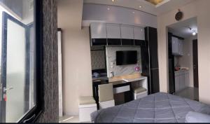 a small room with a bed and a kitchen at Levi Begawan Apartment in Blimbing