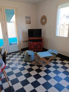 a living room with a checkered floor and a tv at Maison charmante à Port-Bail-sur-Mer, grand jardin clos in Port-Bail-sur-Mer