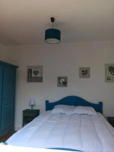 a bedroom with a large white bed with a blue headboard at Maison charmante à Port-Bail-sur-Mer, grand jardin clos in Port-Bail-sur-Mer +11 photos