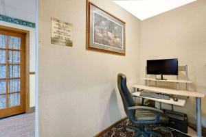 a room with a desk with a computer and a chair at Days Inn by Wyndham North Sioux City in North Sioux City