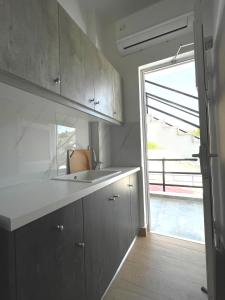 a kitchen with a sink and a large window at Sianos apartments in Gialtra +42 photos