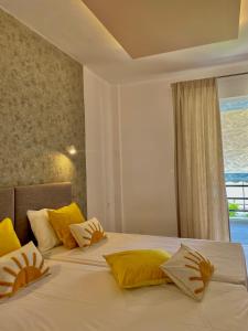 a bedroom with two beds with yellow pillows and a window at Sianos apartments in Gialtra