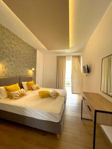 a bedroom with a bed with yellow pillows and a television at Sianos apartments in Gialtra