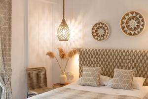 a bedroom with a bed and a pendant light at Hotel Villa Flora in Naxos Chora
