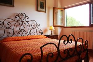 a bedroom with a bed with a red comforter and a window at Villa Amaranto in Panzano +9 photos