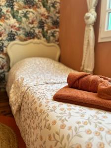 a bed with two towels sitting on top of it at L'Ancienne ferme in Eus