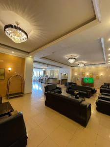 a lobby with black leather couches and a pool table at Hotel Dawa in As Sulaymānīyah