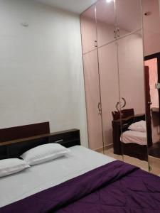 a bedroom with a bed and a mirrored cabinet at Home Stay Near Airport in Chennai +1 photo