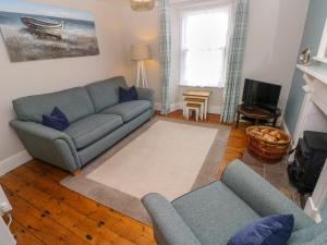 a living room with a couch and a tv at Orielton Cottage in Dinas