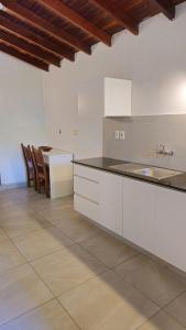 una cucina con mobili bianchi, tavolo e sedie di Apartamentos Don Gerardo ad Asunción