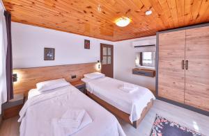 Dos camas en una habitación con techos de madera. en NO 7 Apart, en Kas