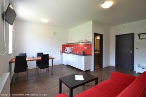 a living room with a red couch and a table at Pension Troll in Rokytnice nad Jizerou