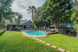 a backyard with a swimming pool and a house at Hout Bay Gem - Elise Way in Hout Bay