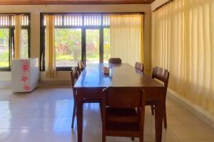 une salle à manger avec une table et des chaises en bois dans l'établissement Raja Asri Guest House Sanur Mitra RedDoorz, à anur 8 autres photos