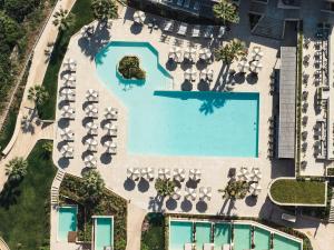 an overhead view of a resort pool with chaise lounge chairs at Cora Hotel & Spa in Afitos