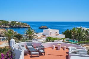 a view of a resort with chairs and the ocean at Villa Esmeralda in Cala d´Or