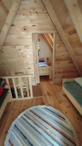 a bedroom in a log cabin with a bed and a rug at Vikendica Izvor in Podgorica