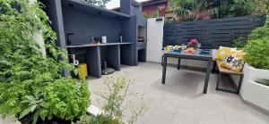 a patio with a table and some plants at Private fenced garden with BBQ area minutes from the beach - Urban Secret Kantrida in Rijeka +41 photos