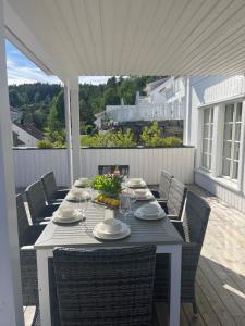 a table on a porch with chairs and a tableablish at Sørlandsidyll, Risør in Søndeled