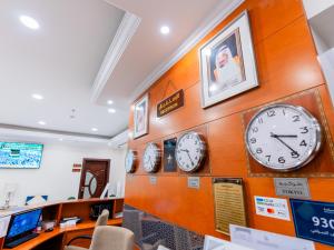 a row of clocks on a wall in a store at Farah Hotel Apartments in Jeddah