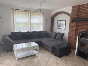 un soggiorno con divano e camino di Freistehendes Haus mit großem, eingezäunten Garten, Sauna, Kamin a Krummhörn