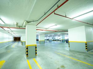 an empty parking garage with white and yellow columns at Farah Hotel Apartments in Jeddah