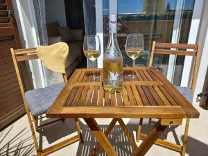 a wooden table with two glasses of wine on it at Omega Apartments in Premantura