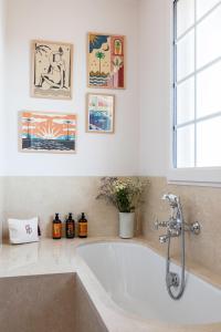 a bath tub in a bathroom with pictures on the wall at Hotel de Silhouette in Biarritz