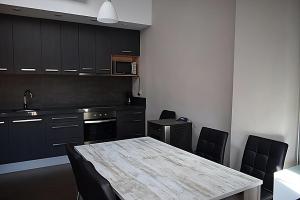 a kitchen with a table and black cabinets and a table and chairs at CASA PETRA in Morella