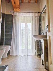 ein Badezimmer mit einem großen Fenster und einem Waschbecken in der Unterkunft Locanda la Rocca Residenza d'Epoca in Fossombrone